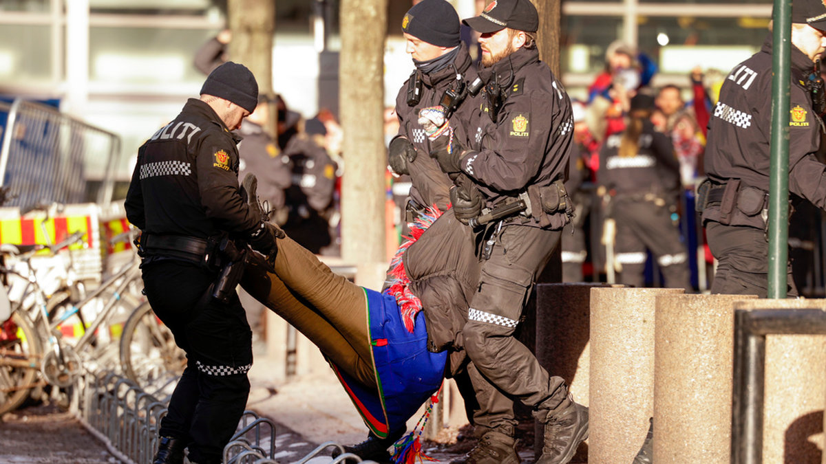 En av demonstranterna bärs i väg av polis i de norska regeringskvarteren.