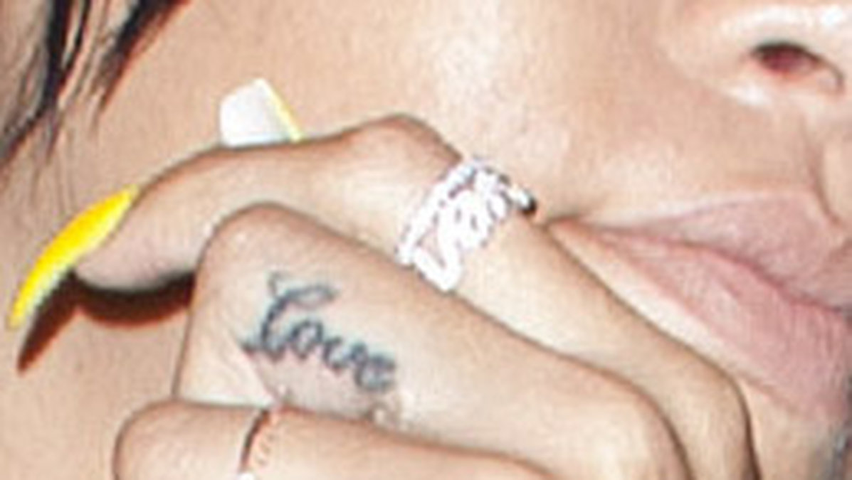 Här ser man tatueringen "love" på hennes finger. 