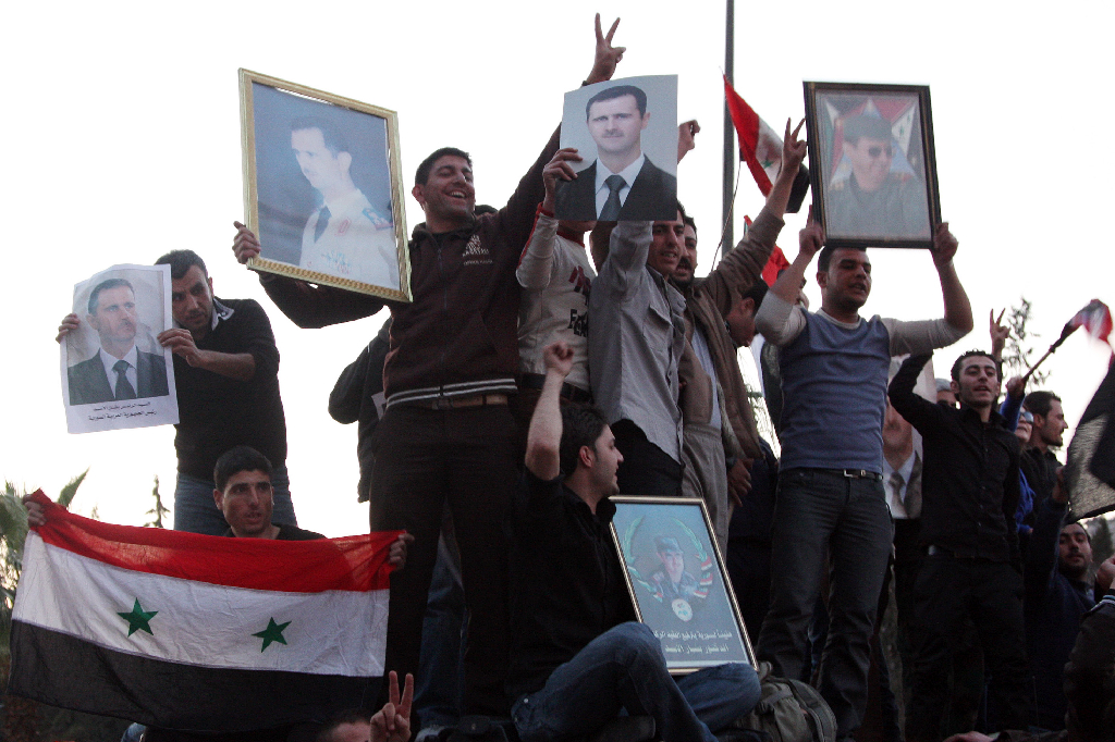 En del syrier står fortfarande på Assads sida. Här är några som skyltar med bilder på honom.