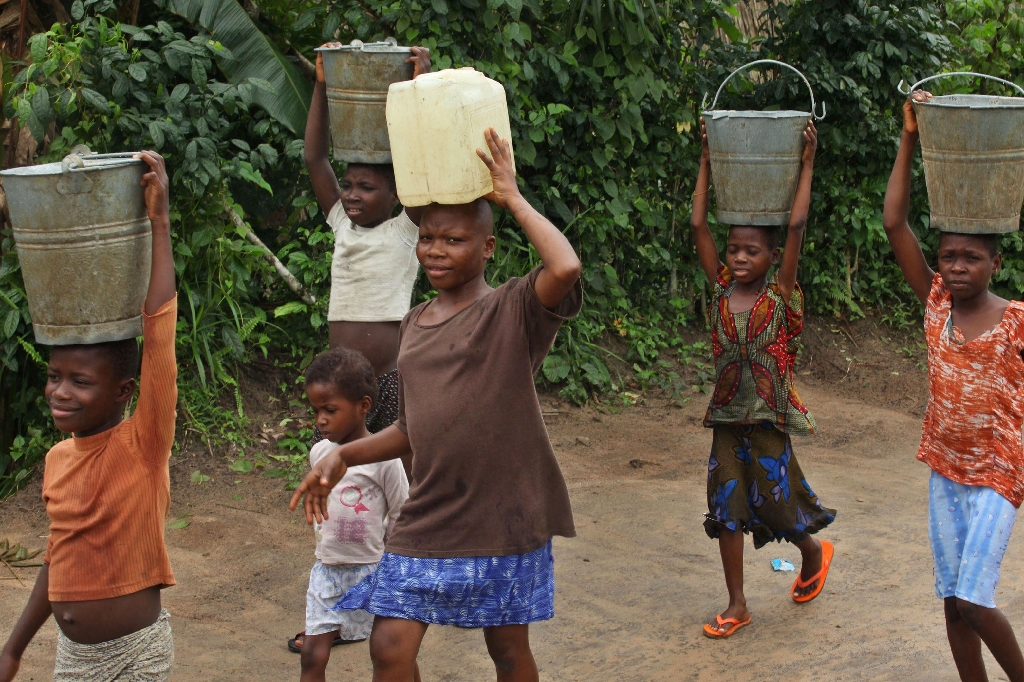 I Afrika anklagas årligen tusentals barn för att vara häxor. Här bär flera av dem vatten i ett läger i Nigeria.