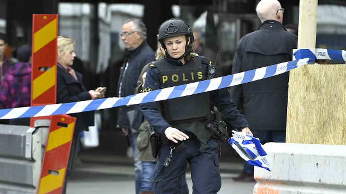 En polis vid avspärrningen intill Åhléns City.