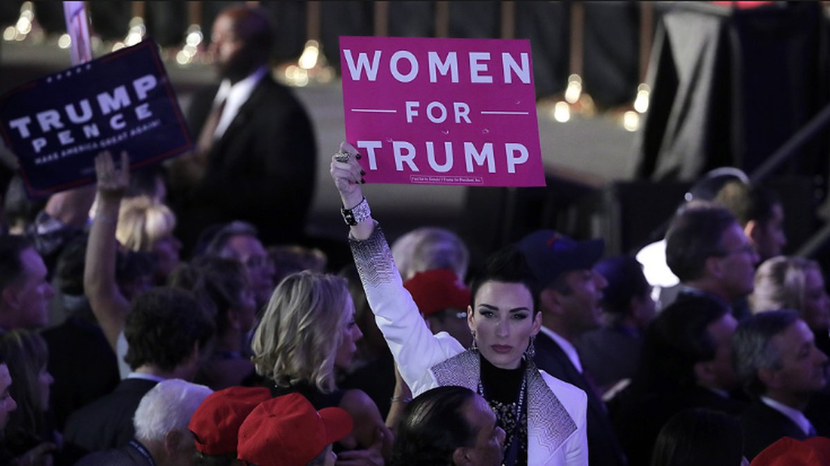 En Trumpsupporter i New York håller upp en skylt med texten "Kvinnor för Trump" under valnatten.