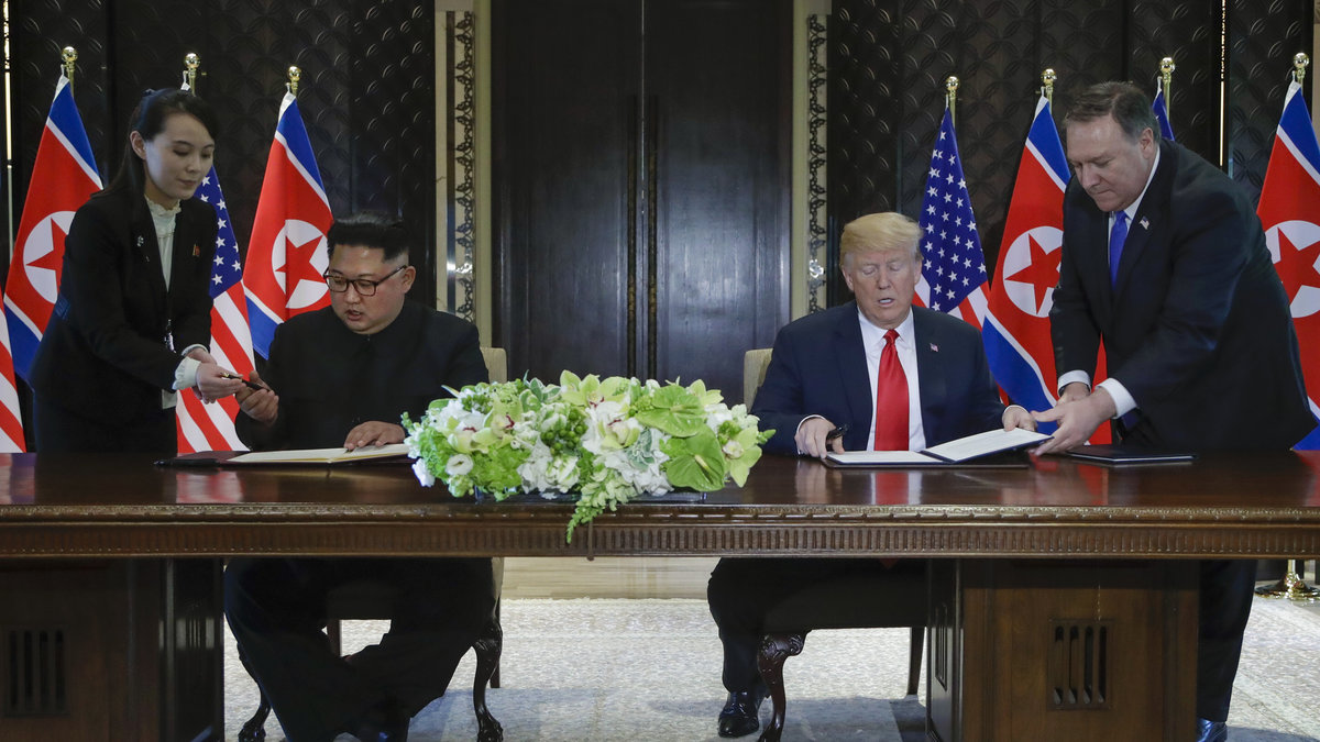 Nordkoreas ledare Kim Jong-un och USA:s president signerar ett dokuement.
