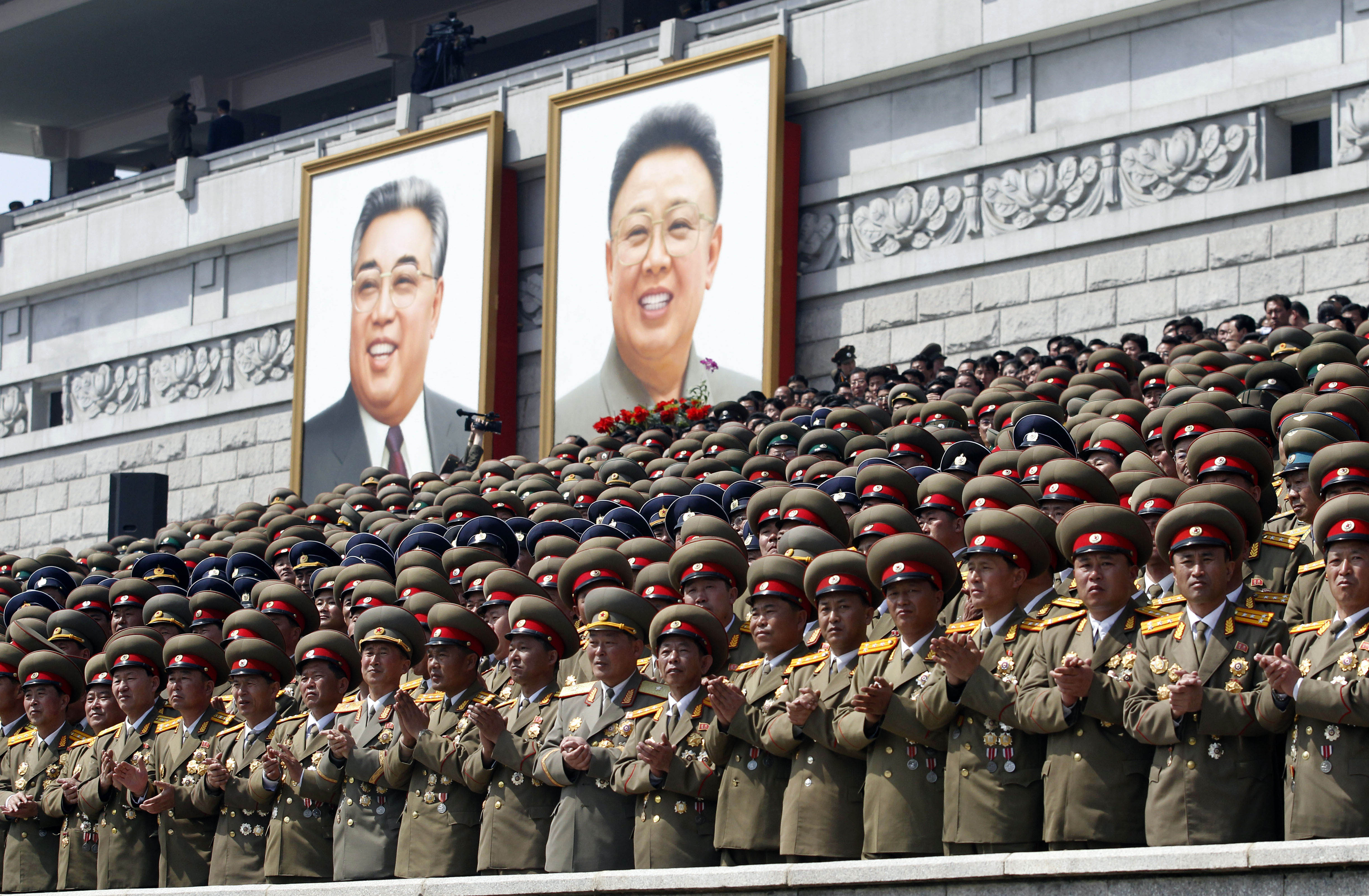 De gamla ledarna Kim II Sung, till vänster på affischen och Kim Jong II, till höger, hyllas av militäriska officierare. De gamla ledarna Kim II Sung, till vänster på affischen och Kim Jong II, till höger, hyllas av militäriska officierare.