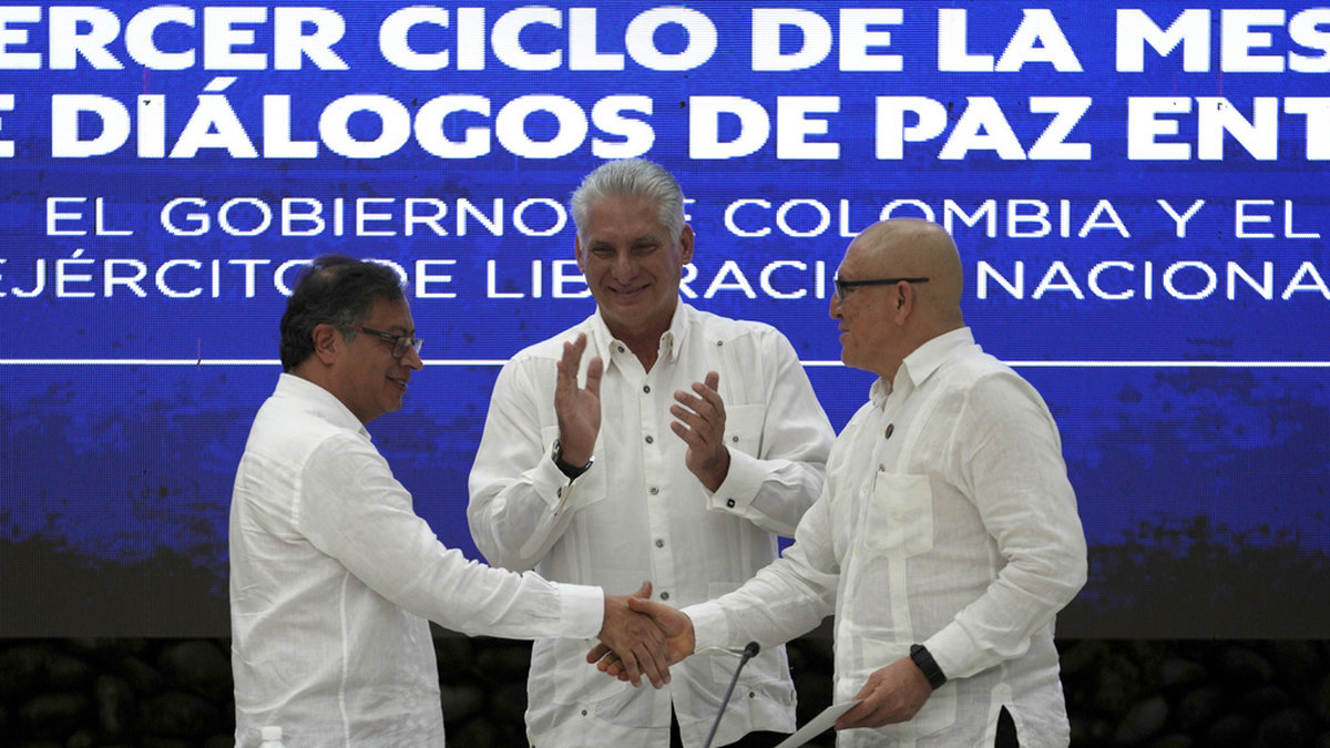 Colombias president Gustavo Petro, till vänster, och ELN-ledaren Antonio García skakar hand efter avtalet om en vapenvila, påhejade av Kubas president Miguel Díaz-Canel, i mitten.