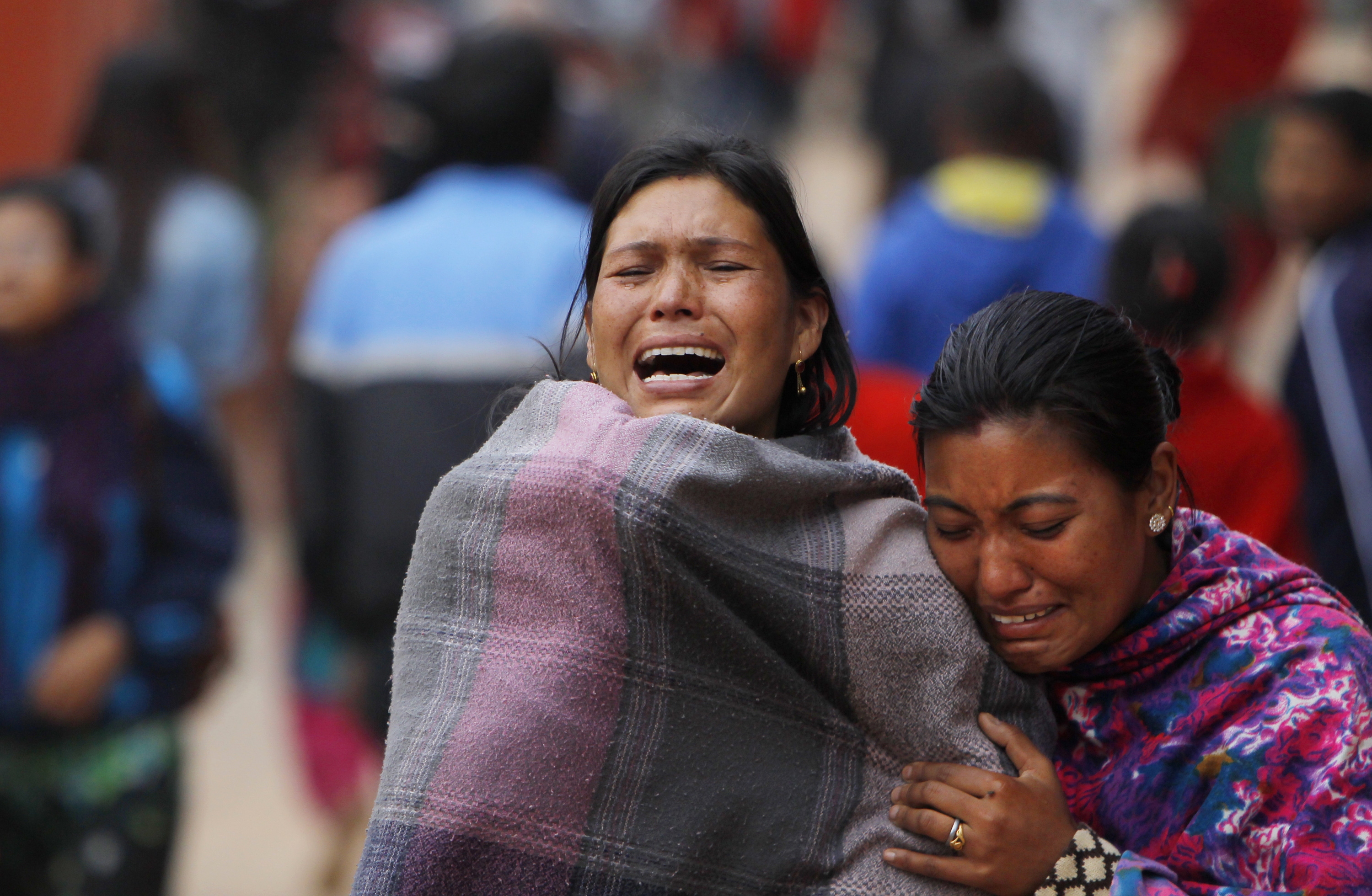 Överlevande familjemedlemmar bryter ihop under en kremering av ett av de tusentals offer som dött av jordbävningen.