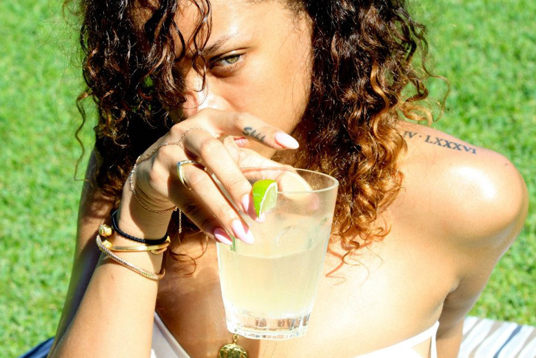 Rihanna, som inte gör en hemlighet att hon gillar att röka på, varvar med en drink i solen.