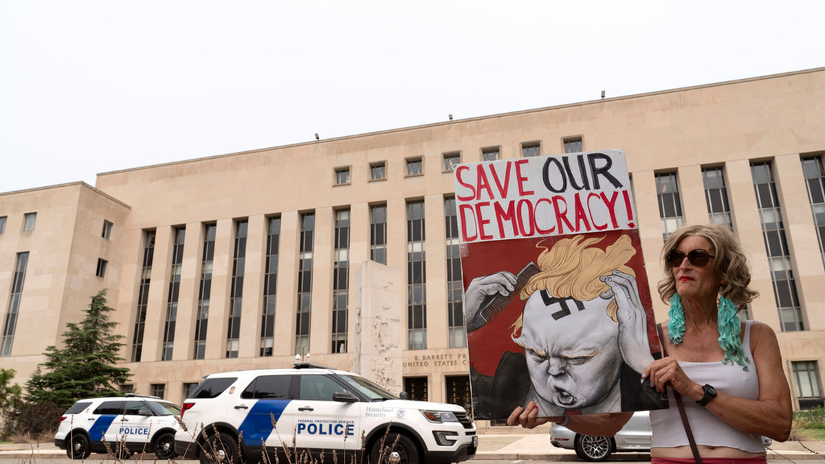 En Trumpkritisk demonstrant utanför domstolen i Washington. Bilden är tagen tidigare i augusti.