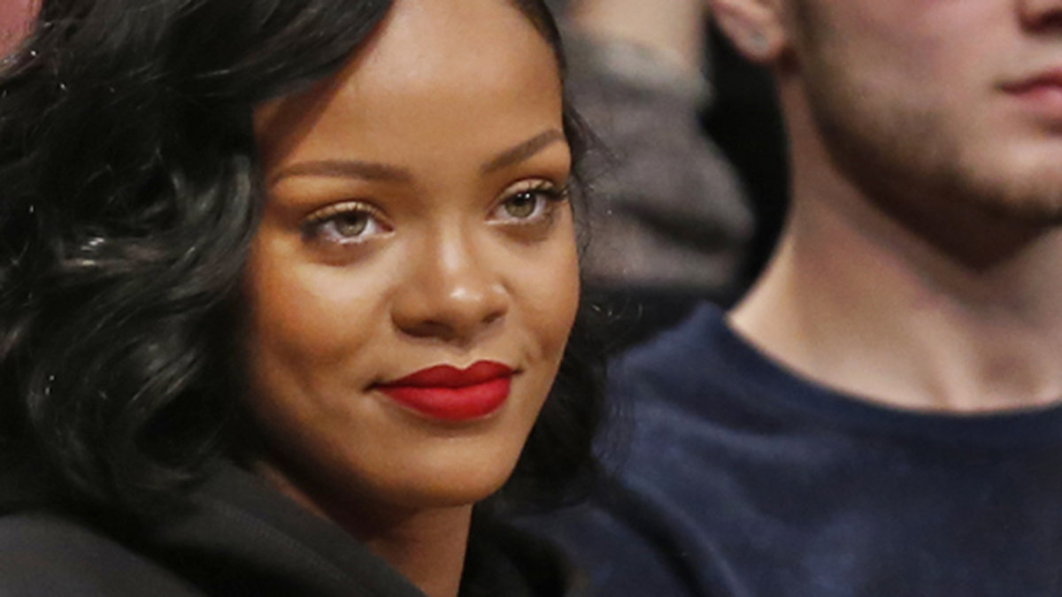 Rihanna smaskar i sig popcorn under en basketmatch. 