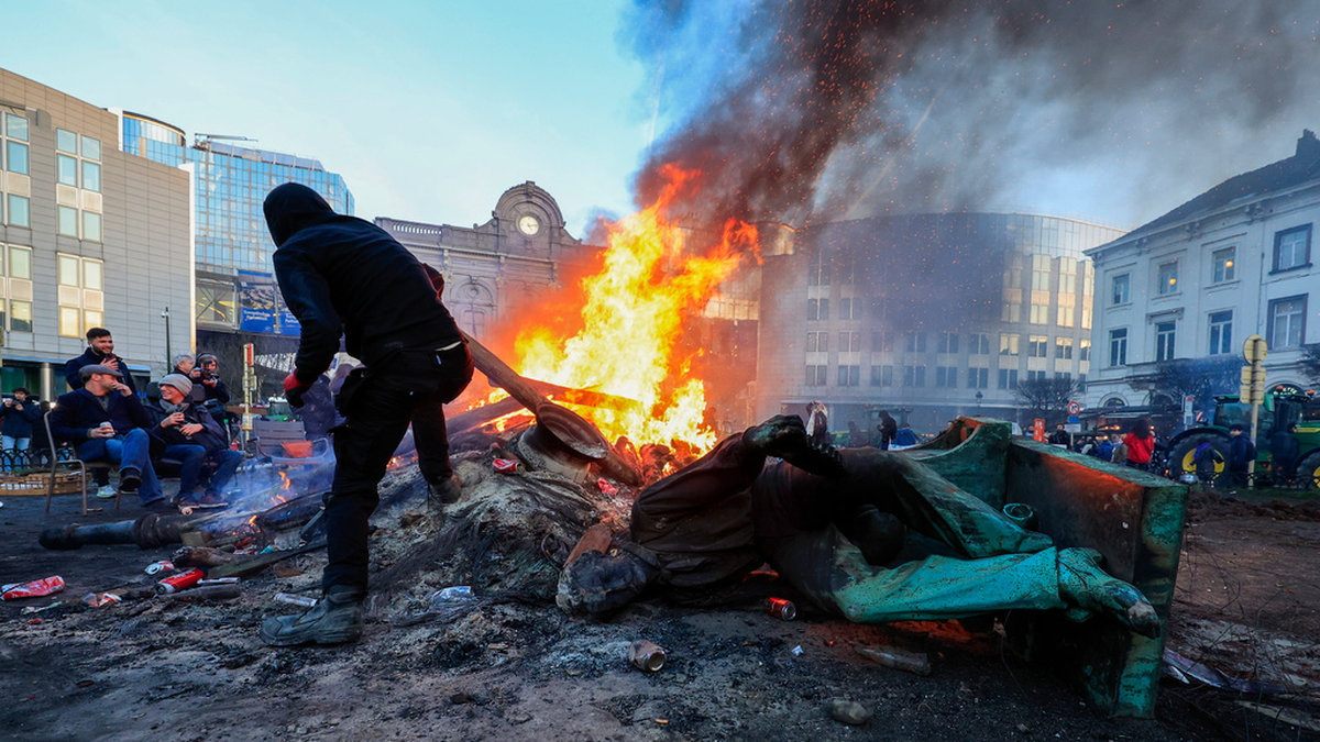 Eldsvådor, traktorer, skräp och en raserad staty på torget utanför EU-parlamentet i Bryssel efter ilskna bondeprotester den 1 februari. Arkivbild.